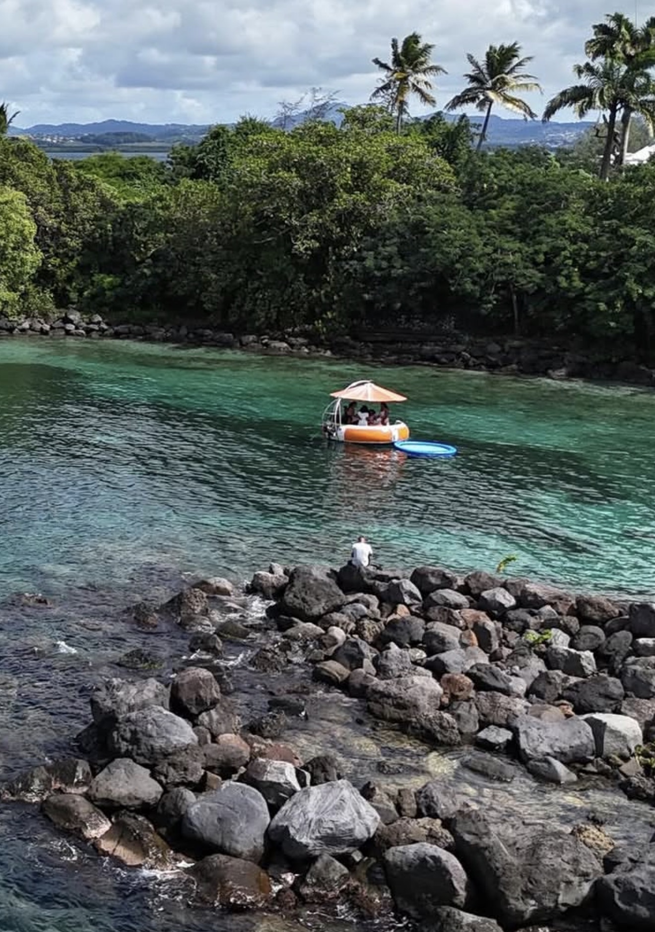 Bateau donut BBQ amarré dans une crique turquoise